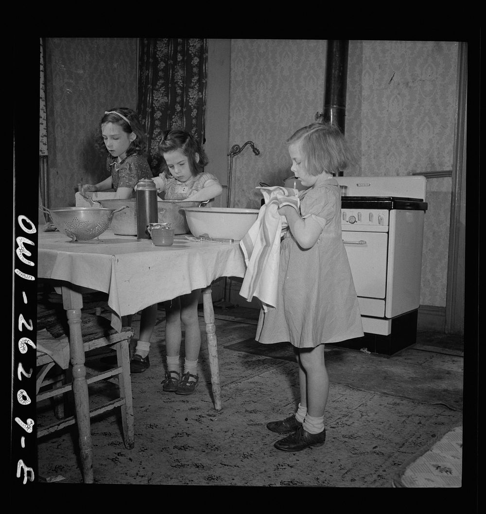 Buffalo, New York. The Grimm children doing the housework. Their mother, a twenty-six year old widow, is a crane operator at…