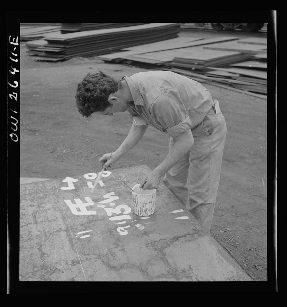 Bethlehem-Fairfield shipyards, Baltimore, Maryland. Painting identification numbers on the steel plates. Sourced from the…