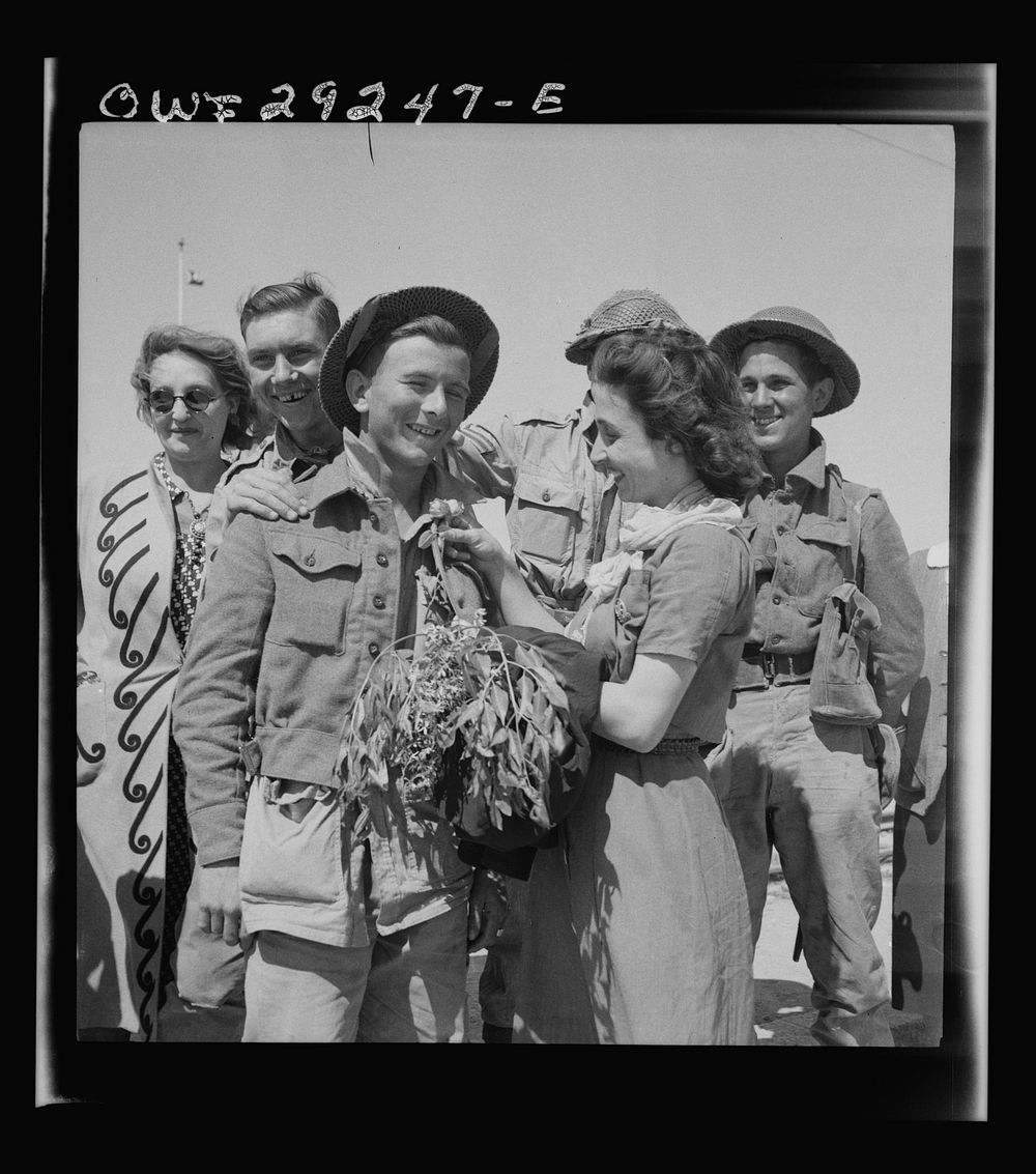 Tunis, Tunisia. A young woman pinning a flower on the coat lapel of a British soldier who entered Tunis with the Allied…