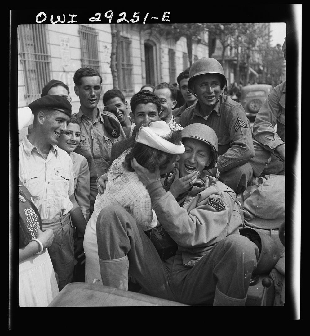 An American correspondent in an Army Jeep is welcomed with a kiss by a young lady in Porto Farina after the Allies…