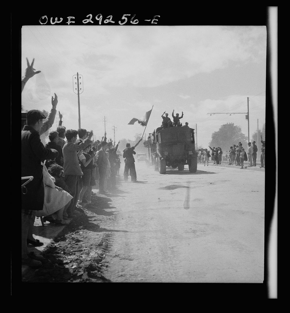 French citizens wave tricolor as the trucks of the Allied Armies enter the outskirts of Tunis. Sourced from the Library of…