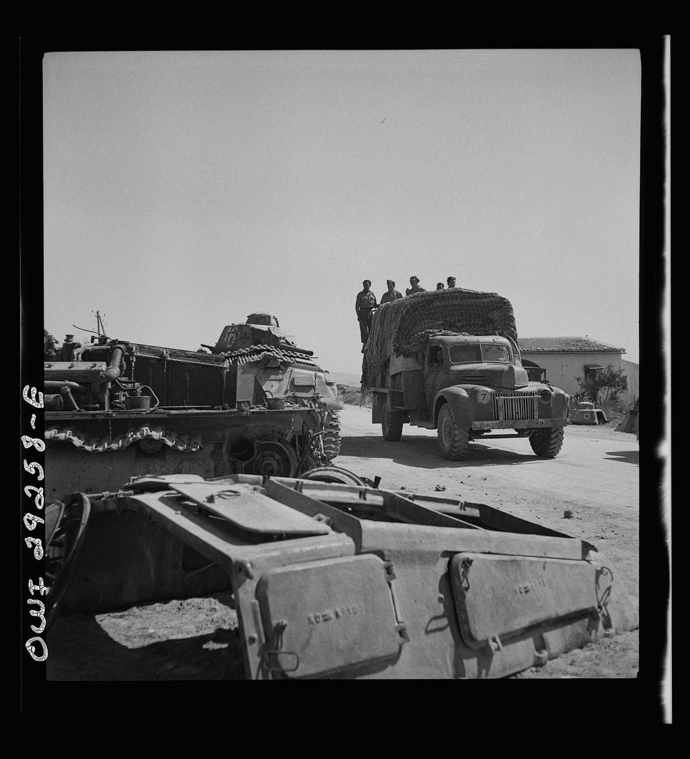 Porto Farina, Tunisia. Allied truck passing wrecked German tanks. Sourced from the Library of Congress.