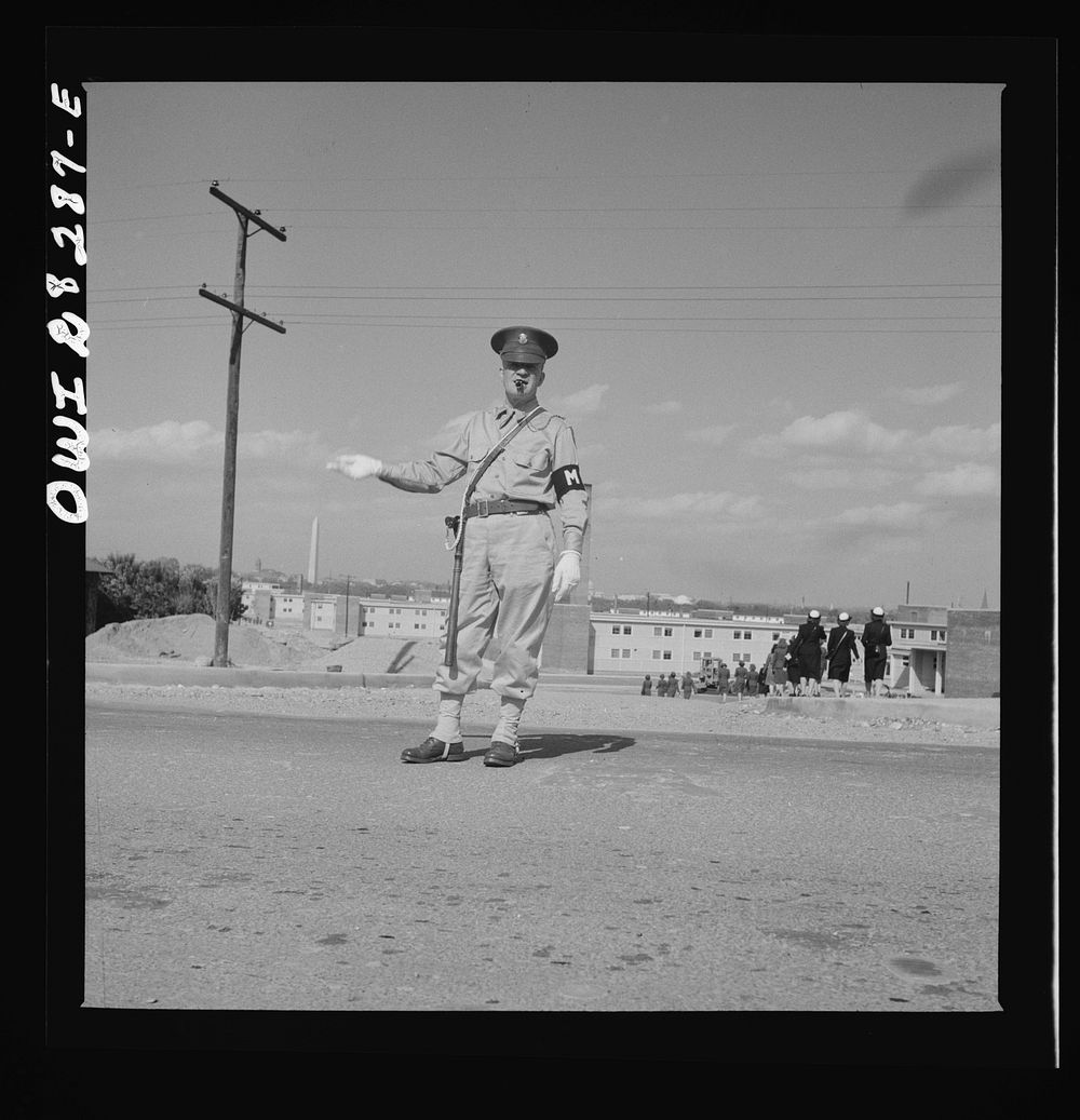 Arlington Farms, war duration residence halls. Military Police acting as traffic officer by the bus stop at Arlington Farms.…
