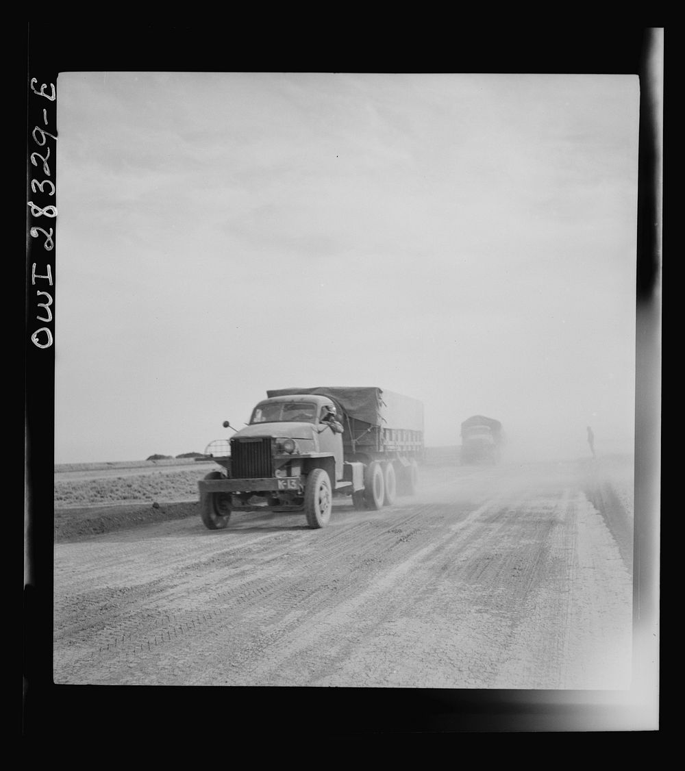 Somewhere in the Persian corridor. A United States truck convoy carrying supplies for the aid of Russia. Trucks are kicking…
