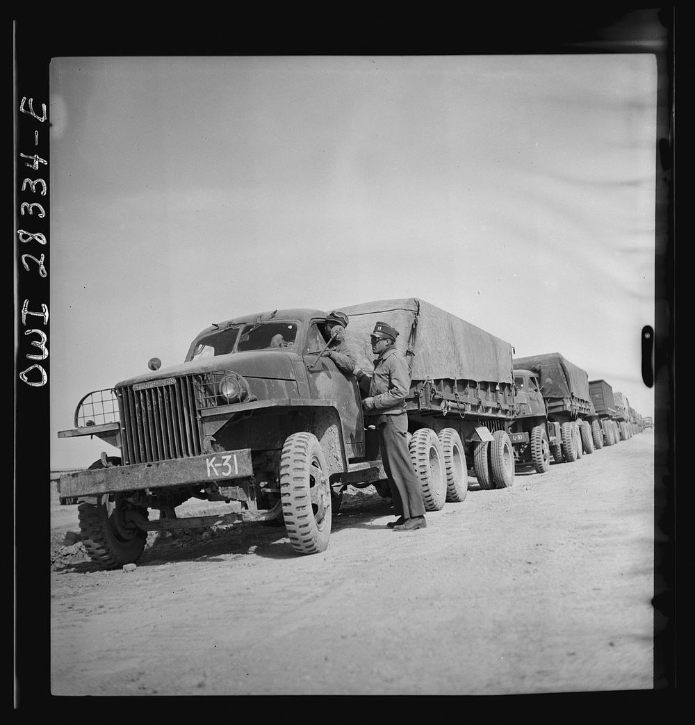 Somewhere in the Persian corridor. A United States Army truck convoy carrying supplies for the aid of Russia. The convoy is…