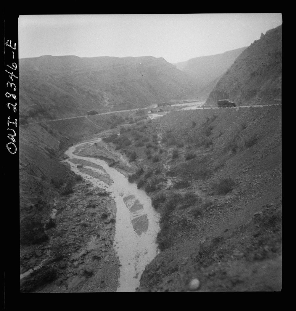 Somewhere in the Persian corridor. A United States Army truck convoy carrying supplies for Russia winding around a gorge in…