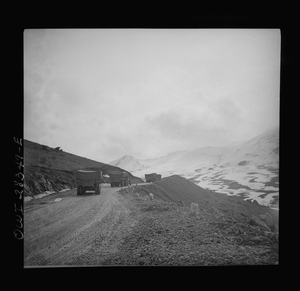 Somewhere in the Persian corridor. A United States Army truck convoy carrying supplies for Russia climbing a mountain road.…