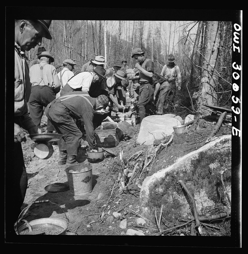Spring pulpwood drive on the Brown Company timber holdings in Maine. At ten o'clock and two o'clock woodsmen eat near their…