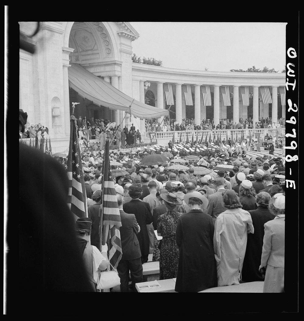 [Untitled photo, possibly related to: Arlington Cemetery, Arlington, Virginia. Spectators putting up umbrellas as a light…