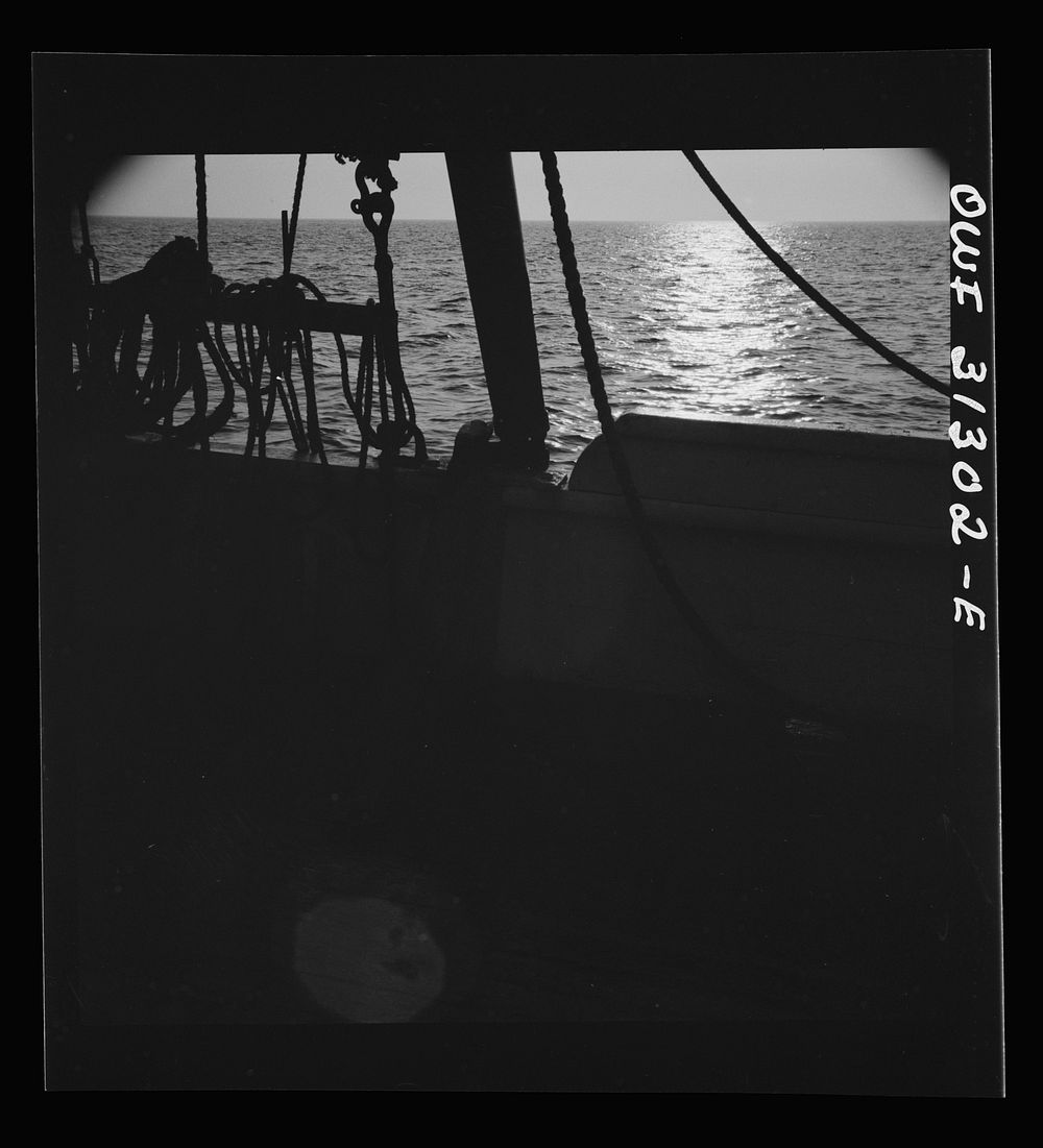 On board the fishing boat Alden, out of Gloucester, Massachusetts. Fishing schooner towing a dory off the New England coast.…