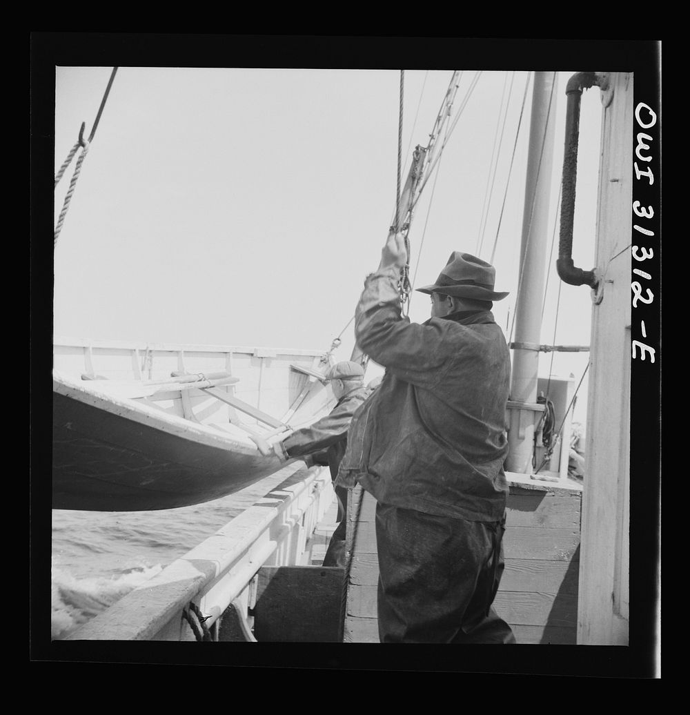 On board the fishing boat Alden, out of Gloucester, Massachusetts. Lowering a lifeboat over the side. Sourced from the…