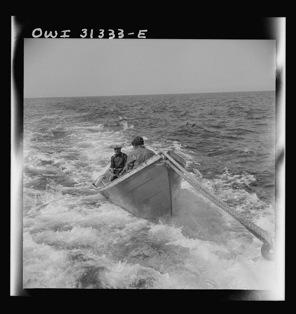 On board the fishing boat Alden, out of Gloucester, Massachusetts. A dory with men, being towed during a mackerel chase.…