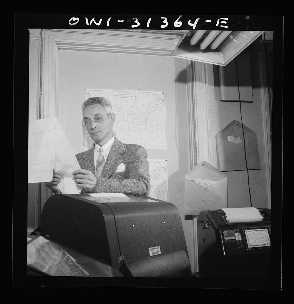 Washington, D.C. Preparing an advisory forecast at the U.S. Weather Bureau. Weather observational reports are received by…