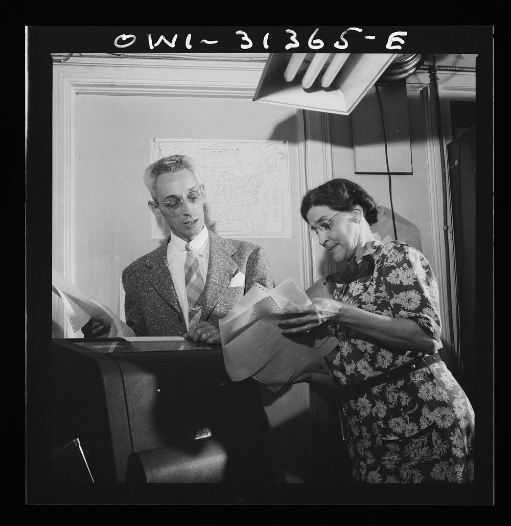Washington, D.C. Preparing an advisory forecast at the U.S. Weather Bureau. Weather observational reports are received by…