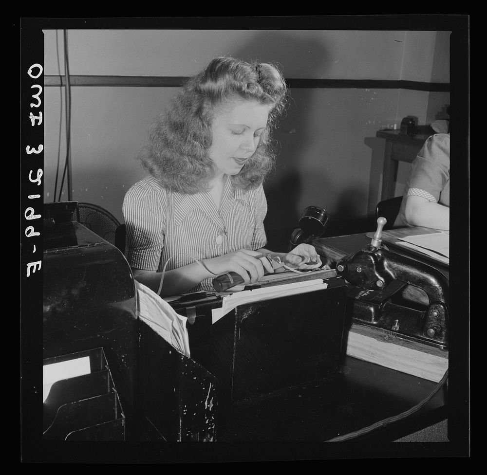 Washington, D.C. Miss Kathleen McCarthy, a Western Union teleprinter operator, receiving gumming telegraph messages. Sourced…