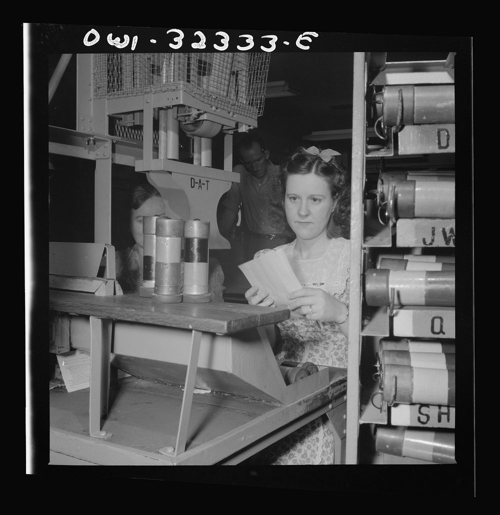 Washington, D.C. Mrs. Eva Poovey working with pneumatic tubes from which telegrams are taken at the Western Union telegraph…