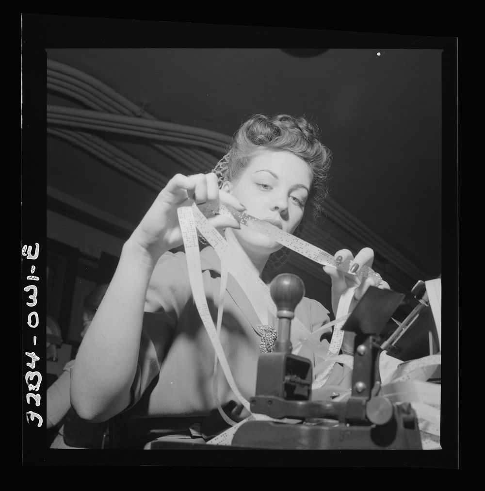 Washington, D.C. Miss Genie Lee Neal reading a perforated tape at the Western Union telegraph office. Sourced from the…