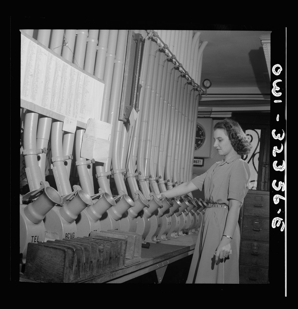 [Untitled photo, possibly related to: Washington, D.C. Miss Helen Ringwald works with the pneumatic tubes through which…
