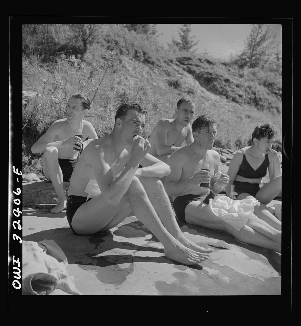 Oswego, New York. United Nations heroes eating a picnic lunch after swimming in Lake Ontario at a swimming party held for…