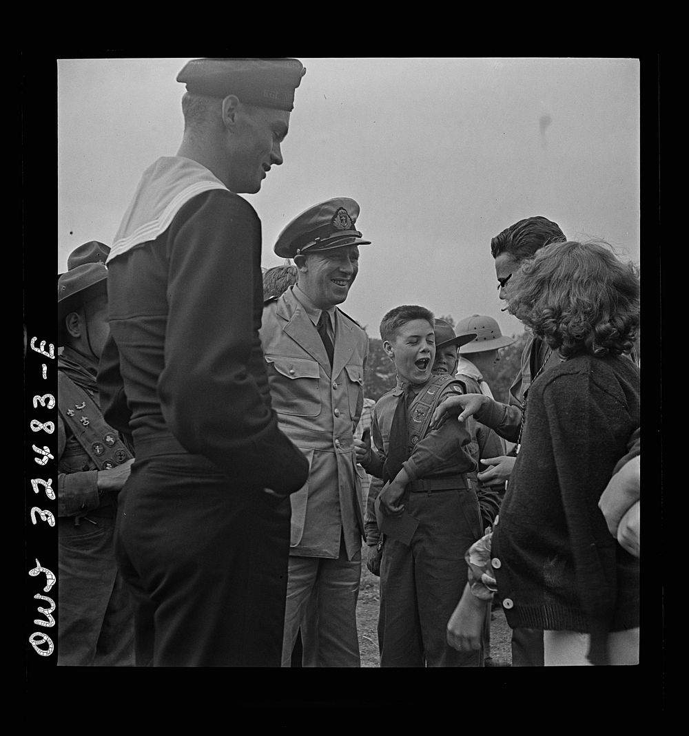 Oswego, New York. Boy scout giving an insignia to a Norwegian naval officer and sailor on Flag Day during United Nations…