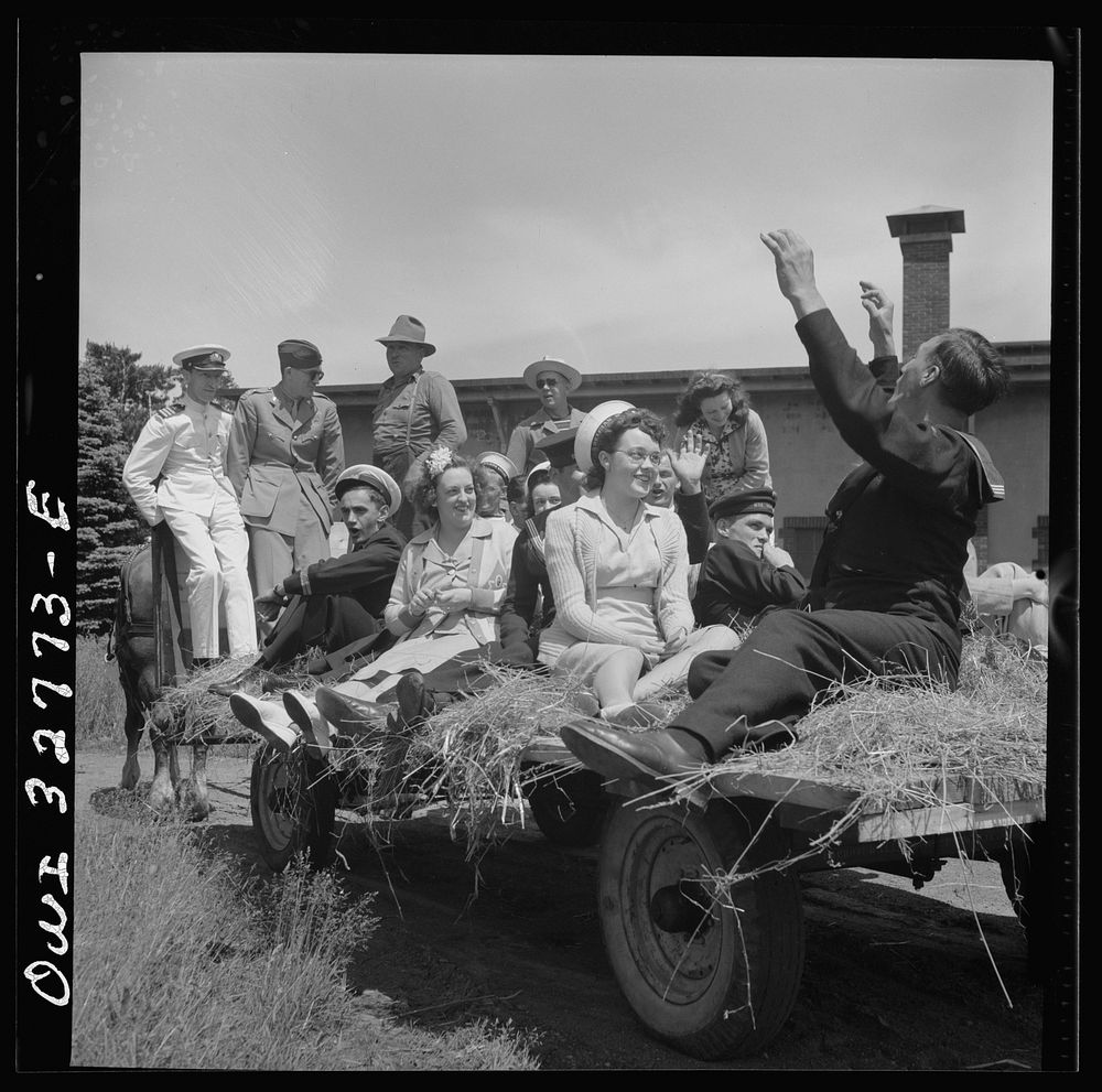 Oswego, New York. Belgian sailor leads singing on a hayride for the United Nations heroes and Oswego girls during United…