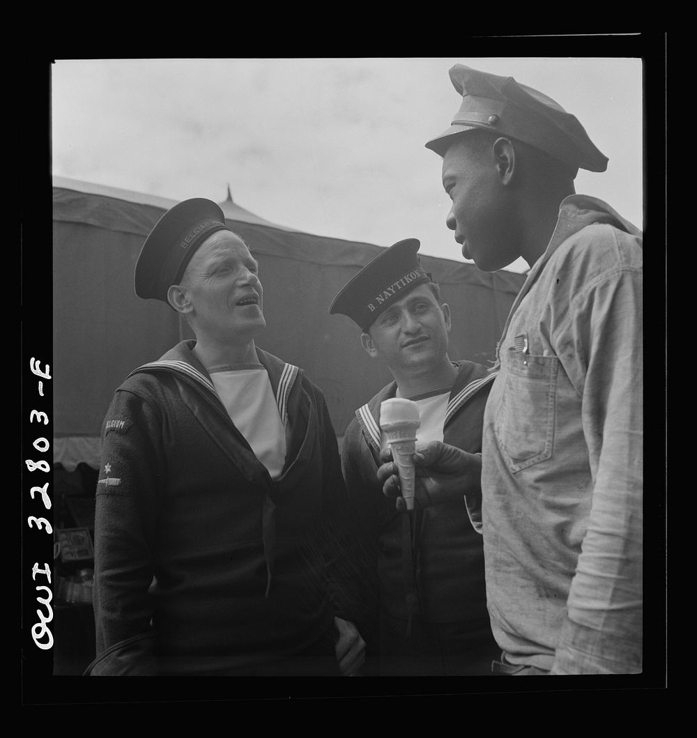 Oswego, New York. Belgian and Greek sailors talking with a  worker at the carnival during United Nations week. Sourced from…