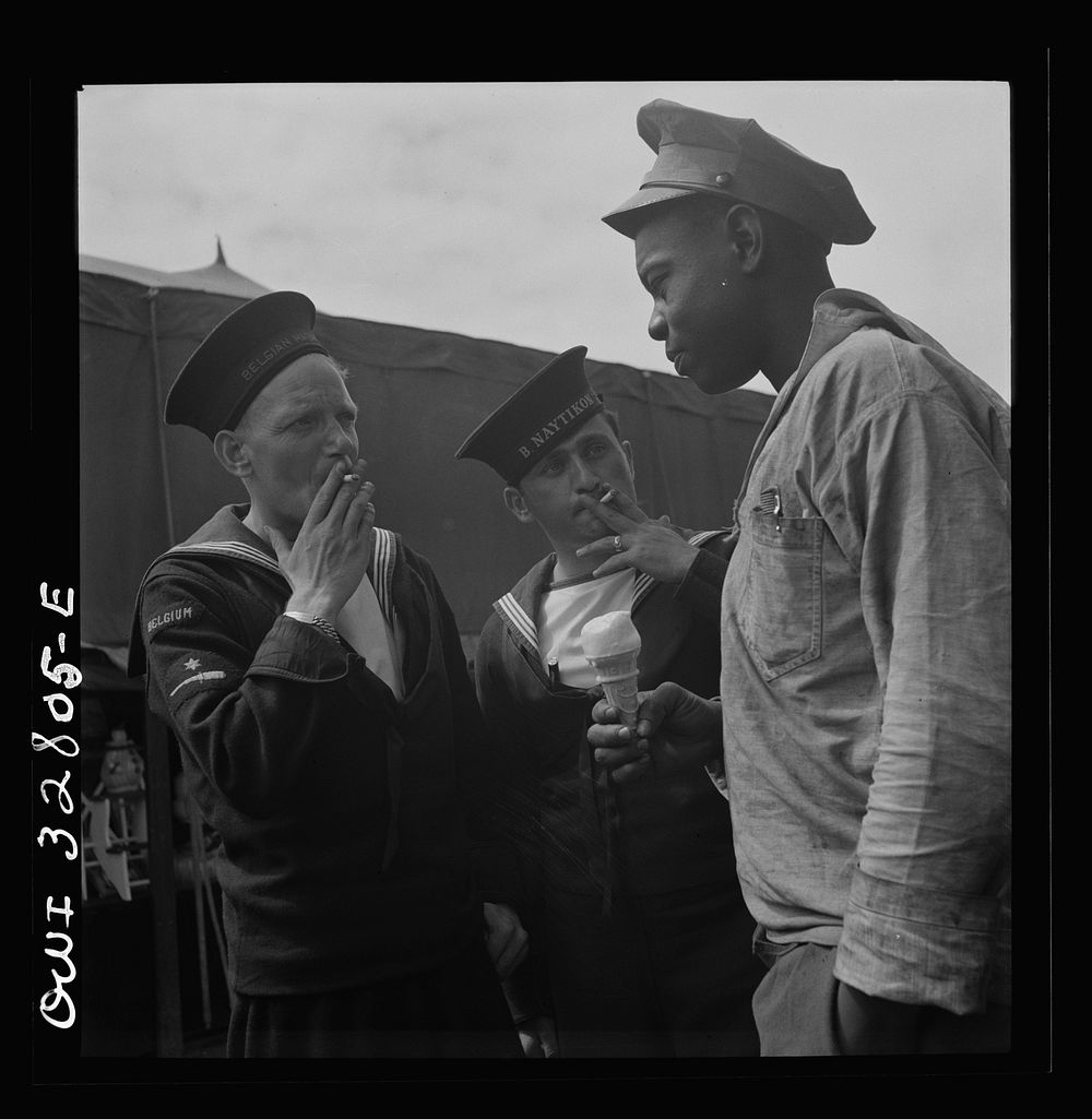 [Untitled photo, possibly related to: Oswego, New York. Belgian and Greek sailors talking with a  worker at the carnival…