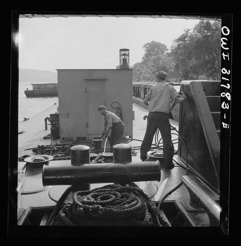 Deckhands at work with cable and ropes aboard in the towboat Ernest T. Weir going down the Ohio River to Cincinnati. Sourced…