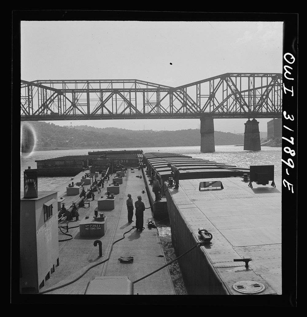 Cincinnati (vicinity), Ohio. Deckhands releasing a barge from the tow of the towboat Ernest T. Weir going down the Ohio…