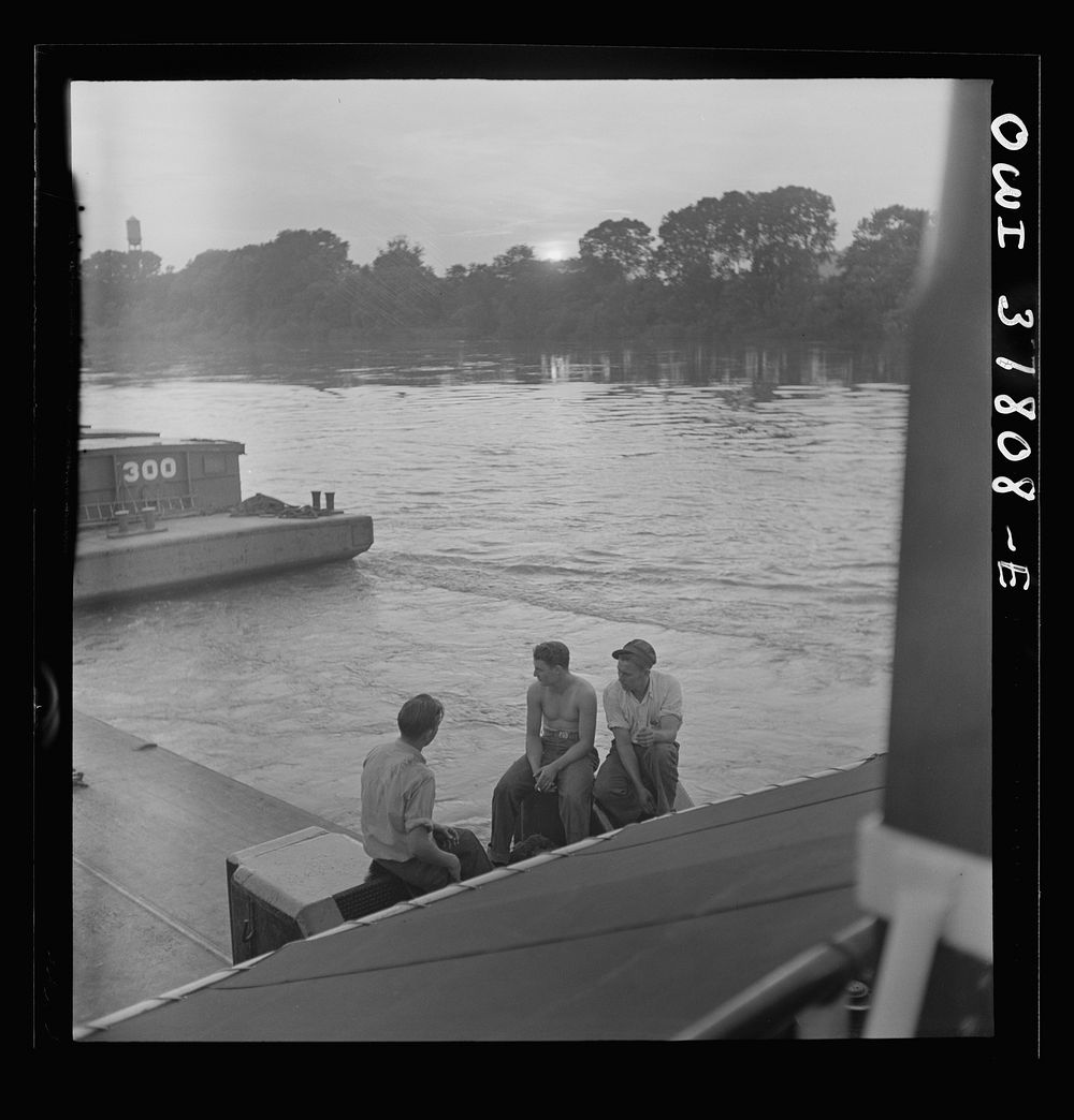 The crew resting in the evening aboard the towboat Ernest T. Weir going down the Ohio River to Cincinnati. Sourced from the…