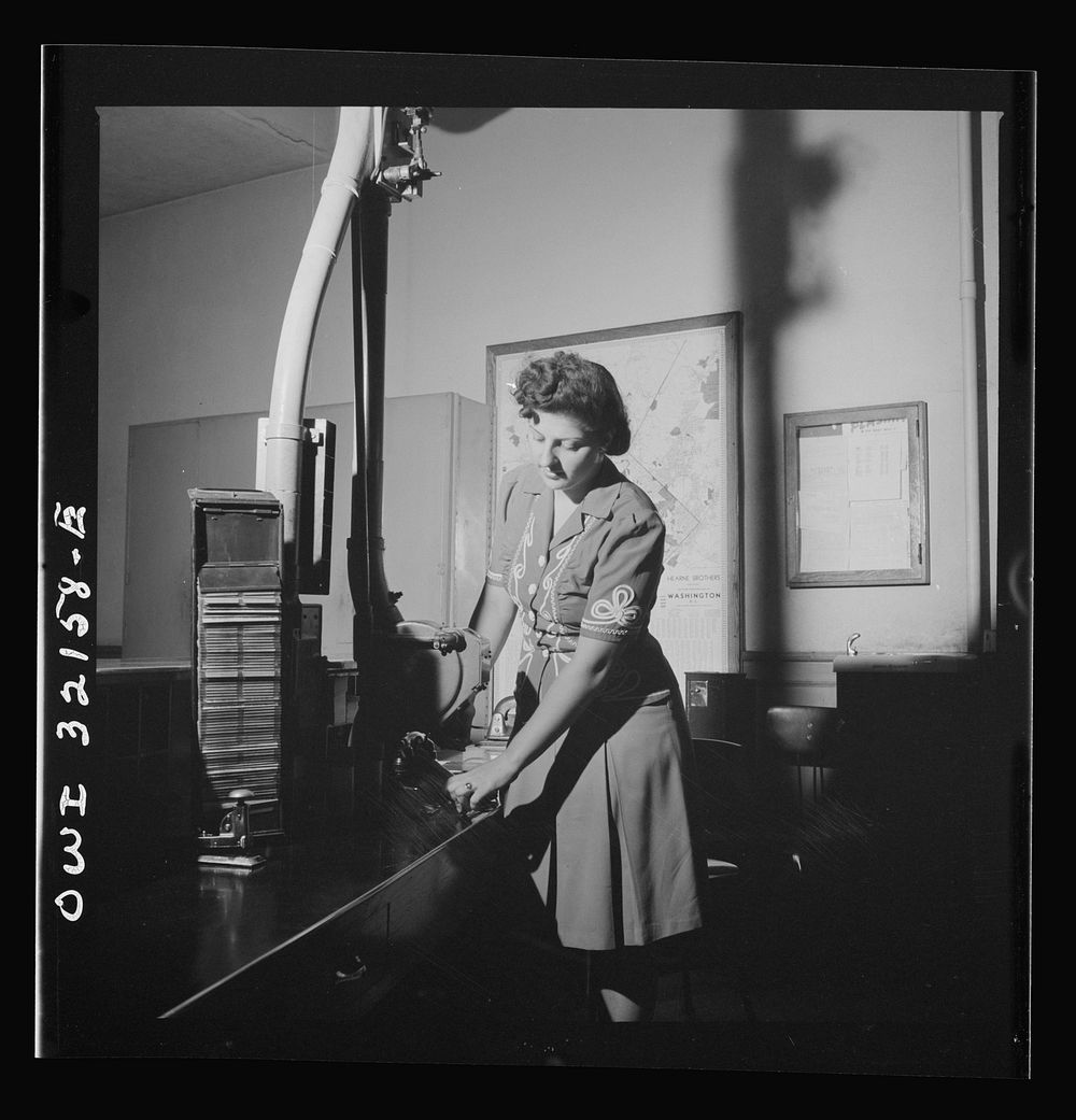 Washington, D.C. Eleanor Ernest taking a cylinder with telegrams from the pneumatic tube in which they have been sent across…