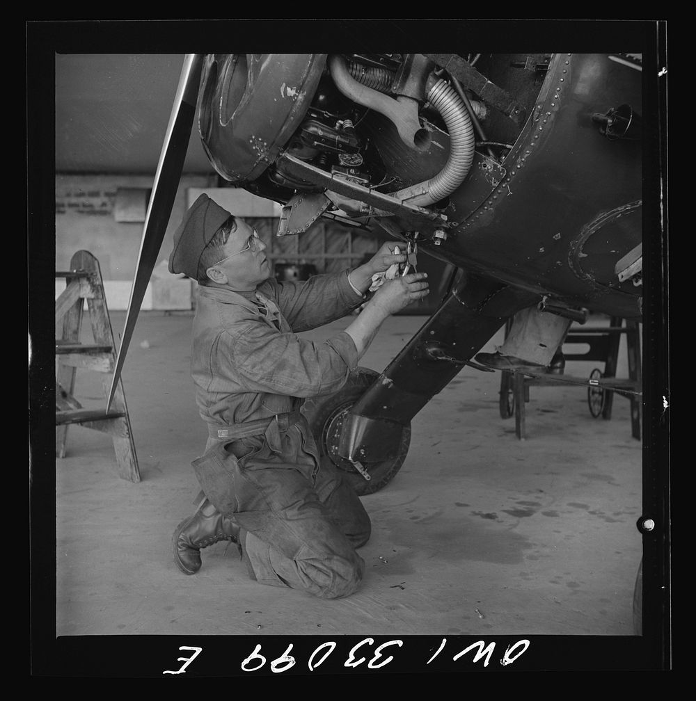 Bar Harbor, Maine. Civil Air Patrol base headquarters of coastal patrol no. 20. Ground crew mechanic making repairs on a…