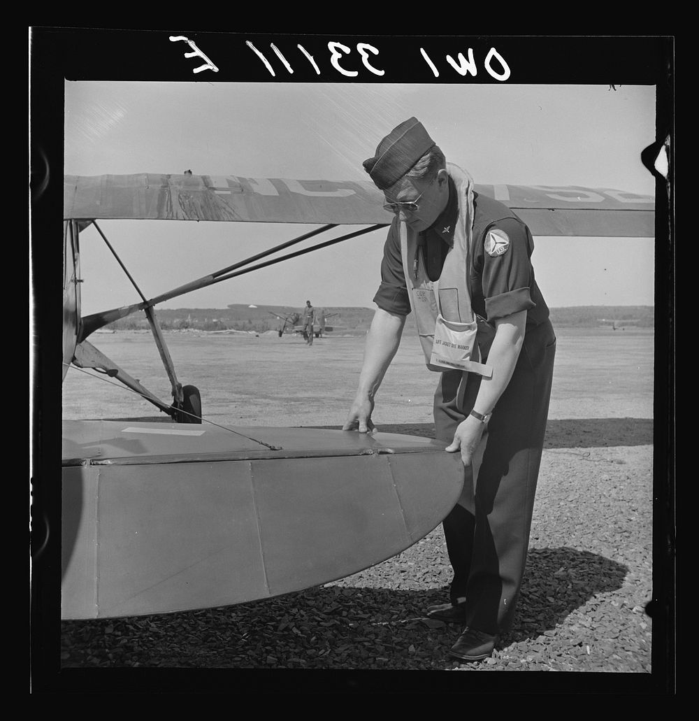 Bar Harbor, Maine. Civil Air Patrol base headquarters of coastal patrol no. 20. Pilot checking the rudder assembly before…