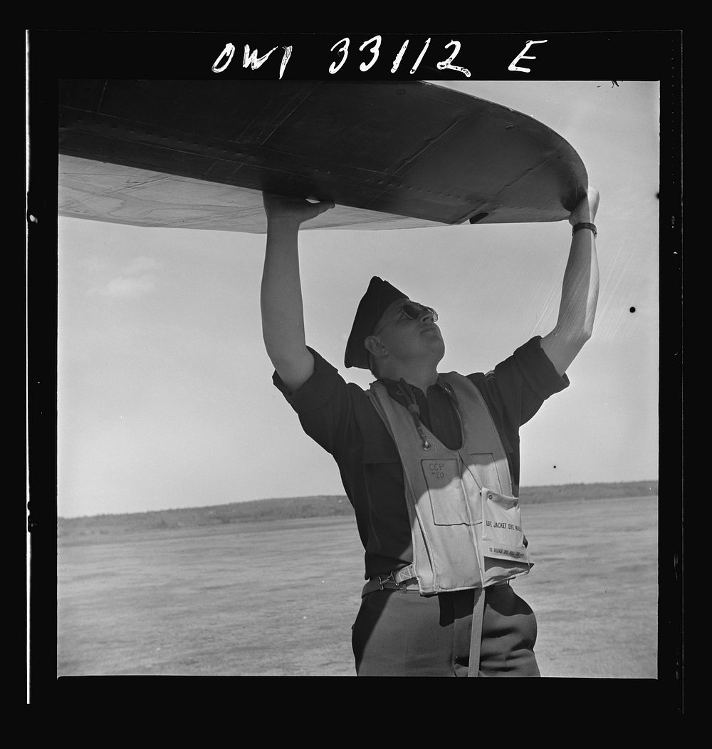 Bar Harbor, Maine. Civil Air Patrol base headquarters of coastal patrol no. 20. Pilot checking airplanes before taking off.…