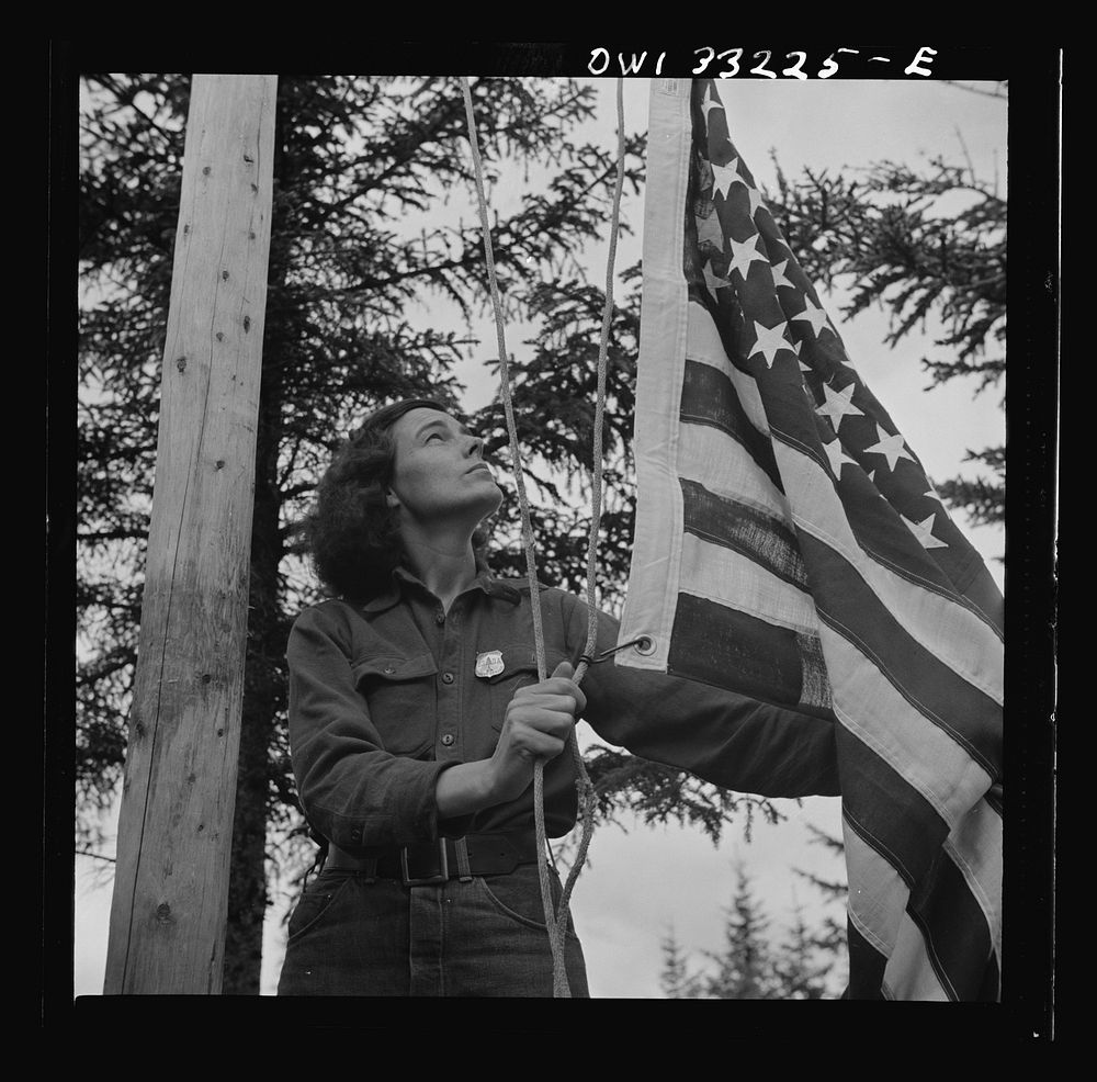 Gorham (vicinity), New Hamphire. Barbara Mortensen, a fire and airplane lookout on Pine Mountain, running up the colors.…