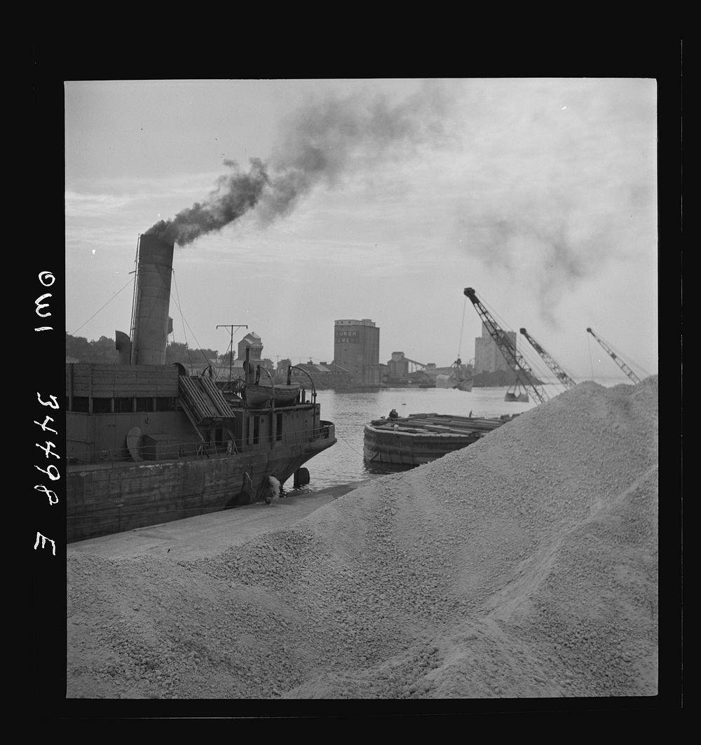[Untitled photo, possibly related to: Oswego, New York. Unloading bauxite from a barge onto a Canadian boat which has come…
