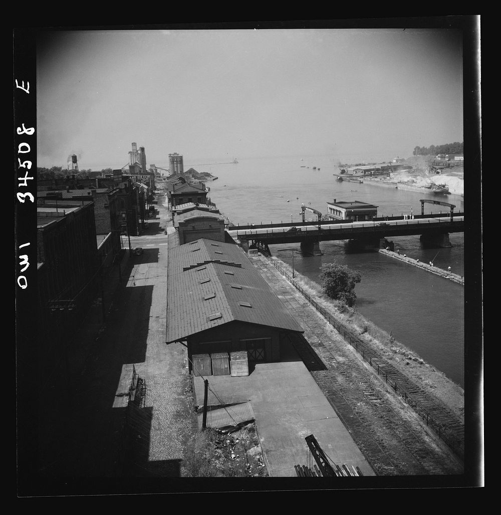 Oswego, New York. The waterfront looking toward Lake Ontario. A grain elevator is in the far left and the bauxite docks are…