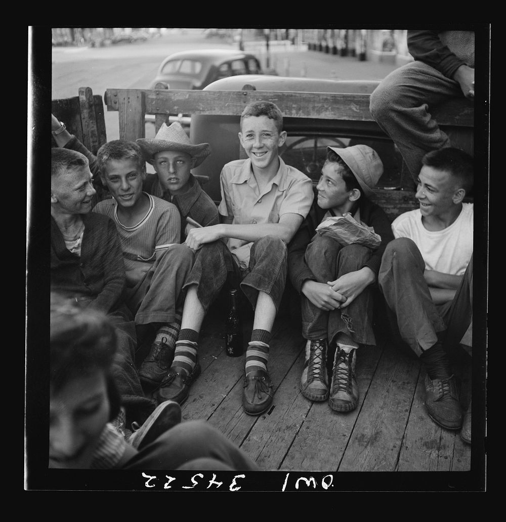 Oswego, New York. Children, recruited for farm work, waiting outside the U.S. Employment Service to start work for the…