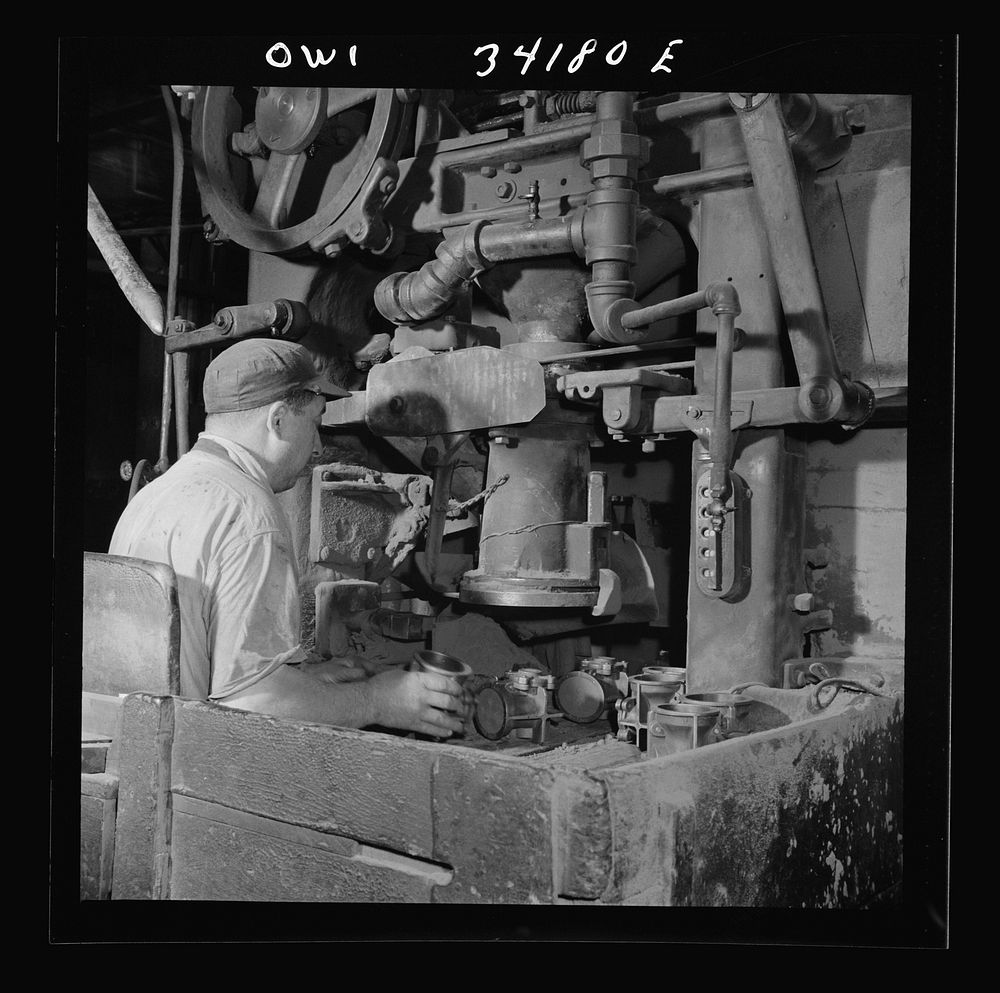 New Britain, Connecticut A core blowing machine. Sand is blown into the core box as it travels away from the machine on a…