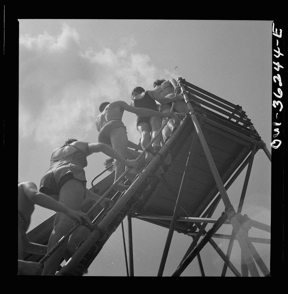 Glen Echo, Maryland. Climbing the ladder to the sliding board at the swimming pool in the Glen Echo amusement park. Sourced…