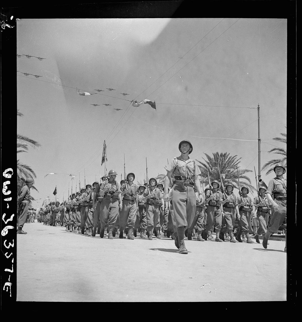 Tunis, Tunisia. French troops passing the reviewing stand in the Allied victory parade along Avenue Gambetta as American…