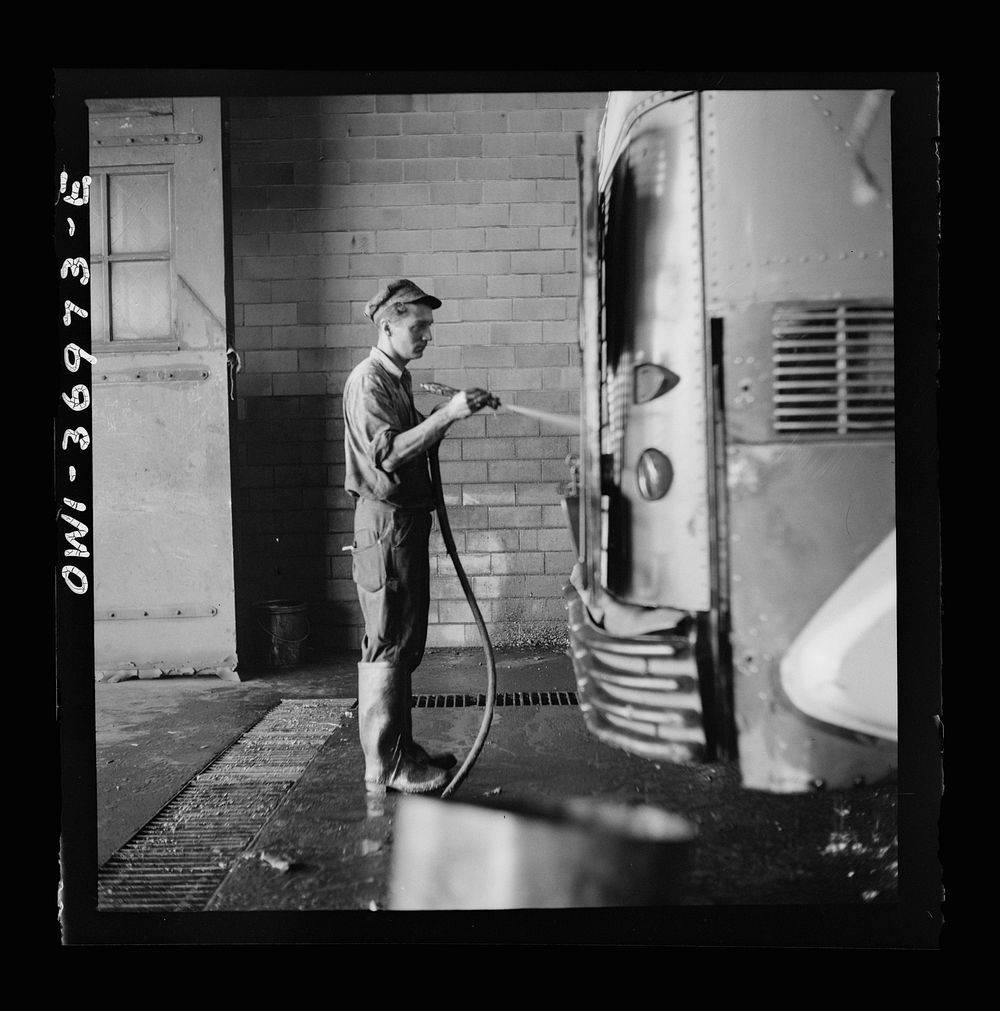 [Untitled photo, possibly related to: Pittsburgh, Pennsylvania. A bus serviceman washing a bus which has just come in from a…