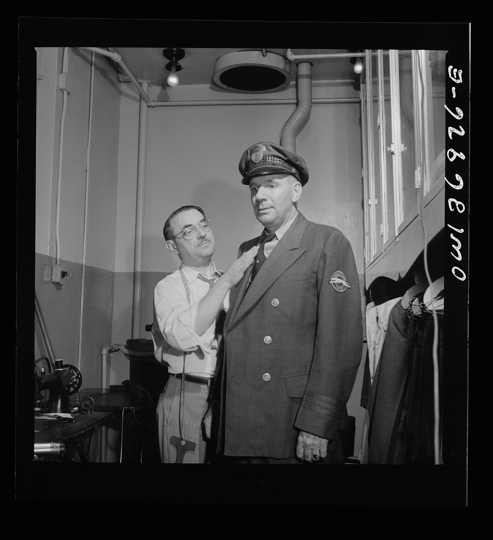 Pittsburgh, Pennsylvania. A tailor fitting a coat at the shop maintained in the Greyhound garage. Drivers pay a dollar a…