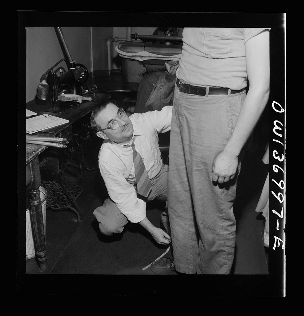 Pittsburgh, Pennsylvania. Isidore Rubinoff, the tailor for the Greyhound Company, measures a new driver for his uniform.…