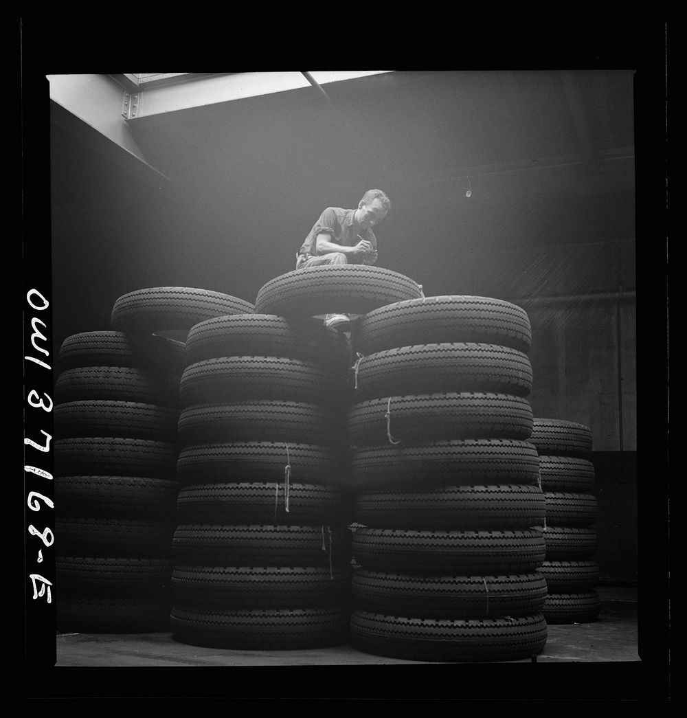 [Untitled photo, possibly related to: Pittsburgh, Pennsylvania. Checking brand numbers on new tires at the Greyhound…