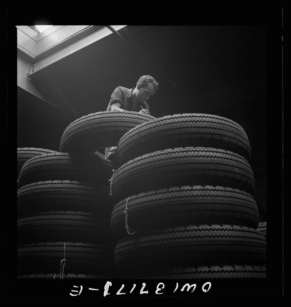 [Untitled photo, possibly related to: Pittsburgh, Pennsylvania. Checking brand numbers on new tires at the Greyhound…