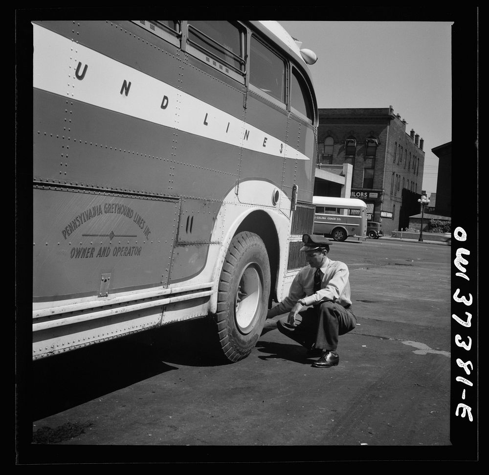 Columbus, Ohio. Randy Pribble, a bus driver for the Pennsylvania Greyhound Lines, Incorporated, checking tires on a bus by…