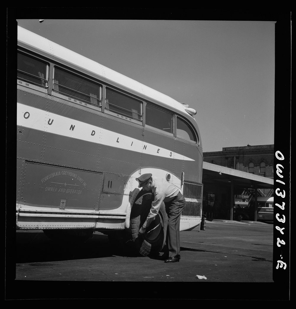 Columbus, Ohio. Randy Pribble, a bus driver for the Pennsylvania Greyhound Lines, Incorporated, checking tires on a bus by…