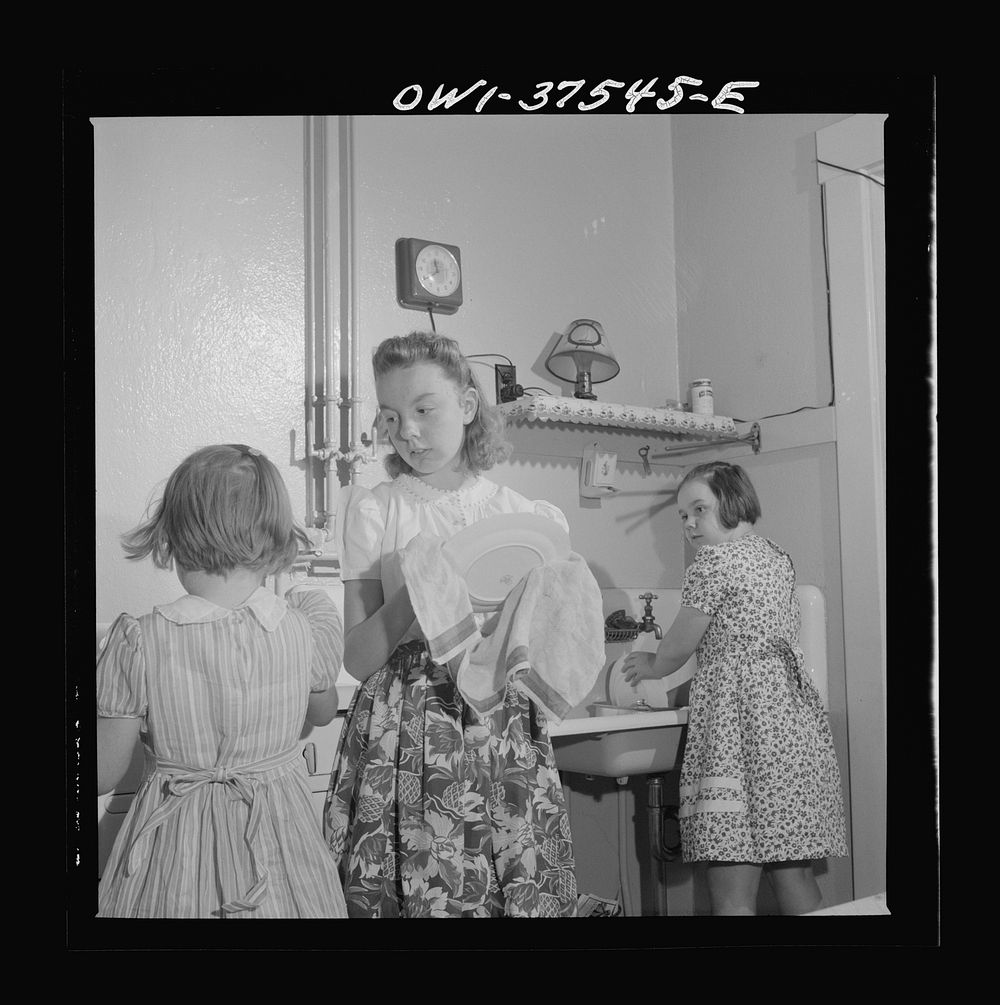 Cincinnati, Ohio. The children of Bernard Cochran, a Greyhound bus driver, doing dishes after a Sunday dinner. Sourced from…