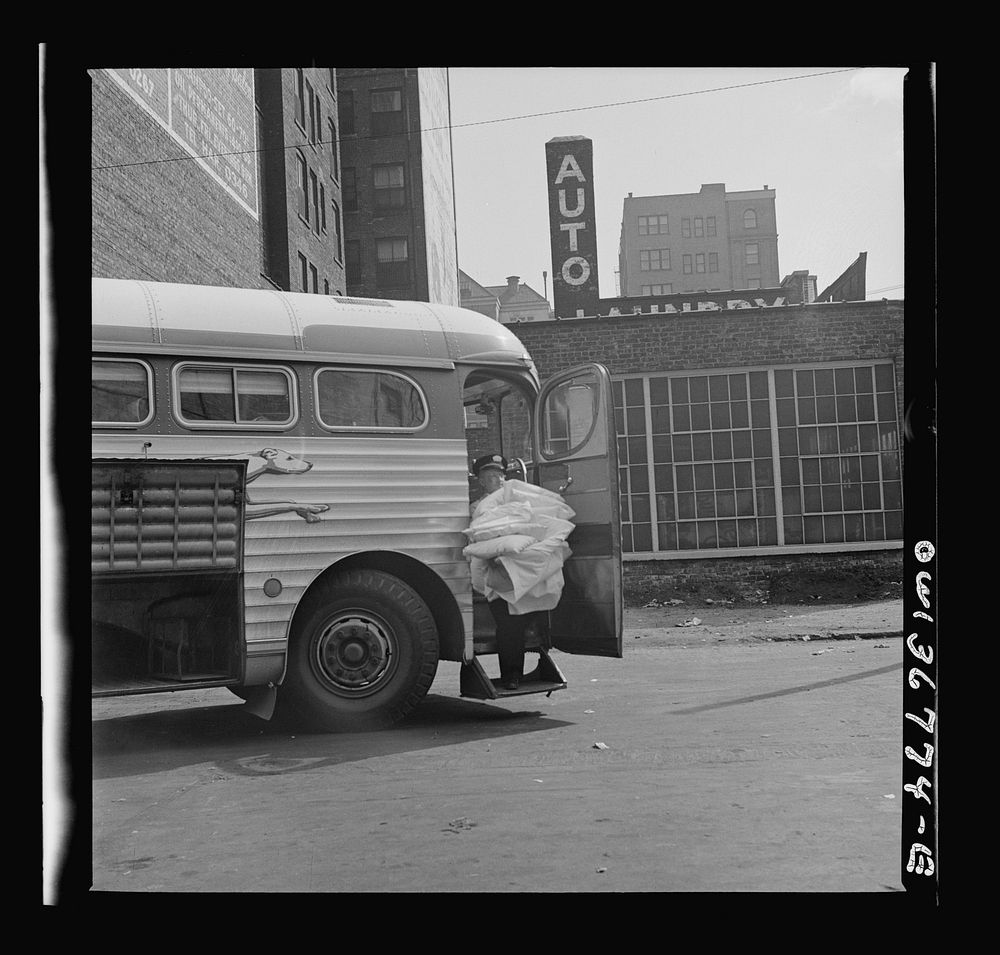 Chicago, Illinois. A pillow man at the Greyhound bus terminal taking used pillows from a bus that has just come in. Sourced…